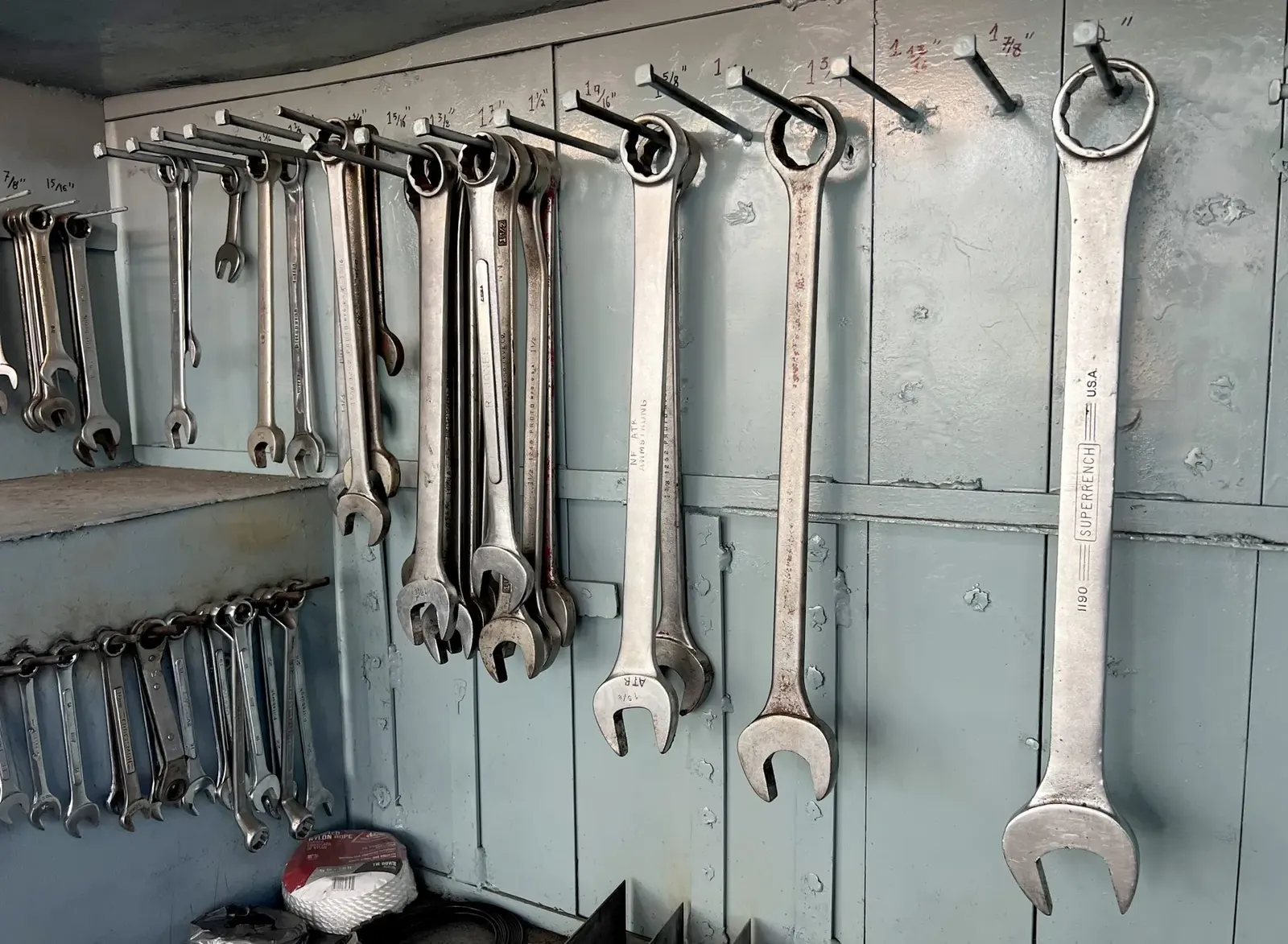 Spanners and wrenches hanging in rows on a workshop wall